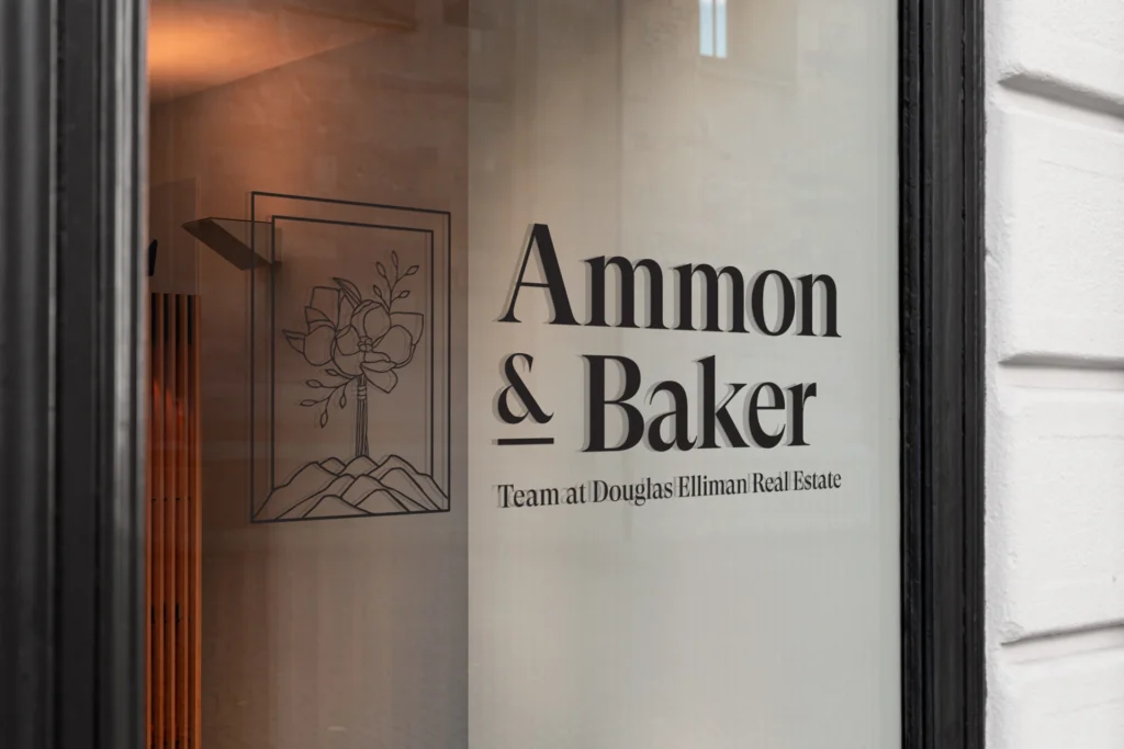 Mockup of Ammon Baker brand identity on an office window.